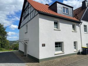 a white house with a red roof at Ferienhaus auffm Hebberg in Attendorn