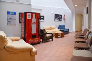a waiting room with a coca cola machine and chairs at Apartamentos AR Dosjoimi in Lloret de Mar