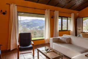 ein Wohnzimmer mit Sofa und Fenster in der Unterkunft Aitxitxe in Karrantza