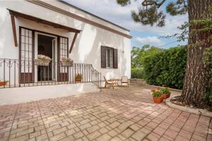 a white house with a patio and a tree at Exclusive Maison Valentina in Monopoli