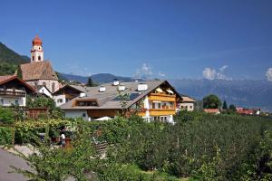a town with a building with a clock tower on a hill at Residence Kronstein - Fewo 4 in Tesimo