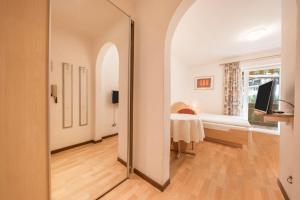 a large mirror in a room with a bedroom at Residence Kronstein - Fewo 4 in Tesimo