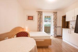 a bedroom with two beds and a window at Residence Kronstein - Fewo 4 in Tesimo