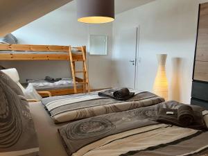 two beds in a room with a bunk bed at Ferienwohnung Sauerlandherz in Lennestadt