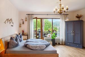 a bedroom with a bed and a large window at Aschaubichl - Wohnung Enzian in Grainau