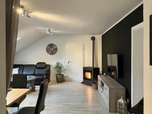 a living room with a couch and a stove at Ferienwohnung Sauerlandherz in Lennestadt