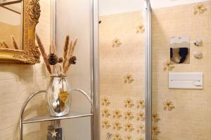 a vase with flowers on a shelf in a shower at Aschaubichl - Wohnung Enzian in Grainau +25 photos