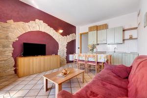 a living room with a couch and a table and a kitchen at Rustico Spagnol 1 in Tignale