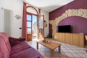 a living room with a couch and a tv at Rustico Spagnol 1 in Tignale