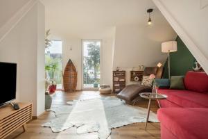 a living room with a red couch and a tv at Seekind in Kressbronn am Bodensee