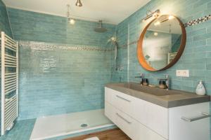 a blue bathroom with a sink and a mirror at Seekind in Kressbronn am Bodensee +16 photos