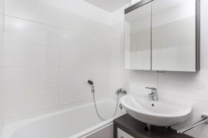 a white bathroom with a sink and a bath tub at The view 2 in Bad Reichenhall +19 photos