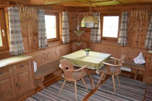 a dining room with a table and chairs in a cabin at Ferienhaus Obersäuling in Stummerberg