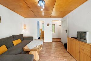 a living room with a couch and a tv at Bungalow 32 - Kimbucht in Reichendorf