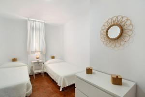 a white room with two beds and a mirror at Casa Boti in Puerto Rico de Gran Canaria +16 photos