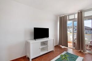 a living room with a flat screen tv on a white cabinet at Casa Boti in Puerto Rico de Gran Canaria