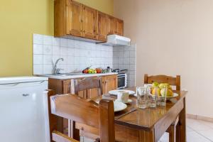 a kitchen with a wooden table with chairs and a sink at Apostolos Apartment 6 in Póndi