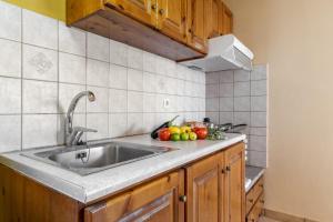 a kitchen with a sink and fruit on the counter at Apostolos Apartment 6 in Póndi