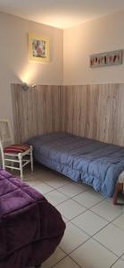 a bedroom with a blue bed and a chair at Domaine de Meslay in Fyé +21 photos