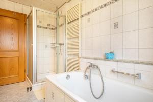 a bathroom with a shower and a bath tub at Urlaub auf dem Hirschhof Stehle in Waldburg +21 photos