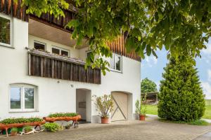 a white house with a tree in front of it at Urlaub auf dem Hirschhof Stehle in Waldburg