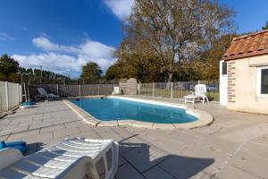 a swimming pool on a patio next to a house at La Grange in Guizengeard