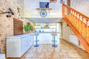 a kitchen with a counter and a staircase at La Grange in Guizengeard