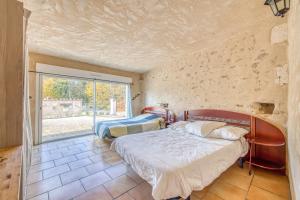 a bedroom with two beds and a large window at La Grange in Guizengeard