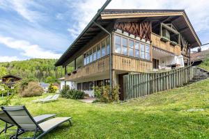 a house on a hill with a chair in the yard at Großes Ferienhaus mit Bergblick in Unterwössen