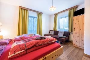 a bedroom with a bed and a couch at Heiserhof App Apfel in Racines