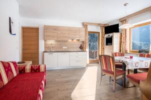 a kitchen and living room with a red couch and a table at Heiserhof App Apfel in Racines +18 photos