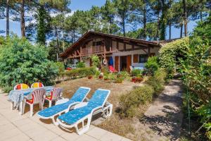 a group of chairs and tables in front of a house at Maison entre Lac et Océan in Biscarrosse