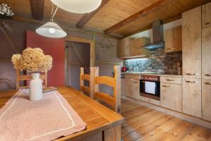 a kitchen with a wooden table with a vase of flowers at Ferienwohnung 'Zur Napoleonschanze' in Rathewalde