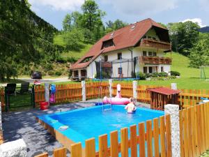 a child in a swimming pool with a house in the background at Schlegelhansenhof in Buchenbach