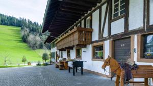 a horse standing outside of a building with a bench at Schlegelhansenhof in Buchenbach