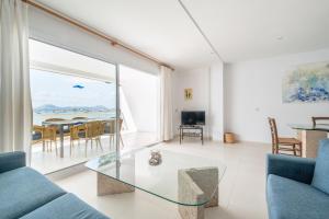 a living room with a glass table and a view of the ocean at Catalina 2a tres dormitorios in Port de Pollensa