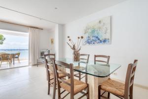 a dining room with a glass table and chairs at Catalina 2a tres dormitorios in Port de Pollensa +24 photos