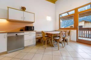 a kitchen with a table and chairs in a kitchen at Apartments Antersi Robbi in San Vigilio Di Marebbe