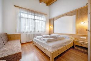 a bedroom with a large bed and a window at Apartments Antersi Robbi in San Vigilio Di Marebbe