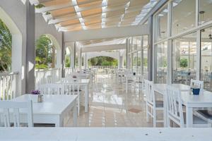 a dining room with white tables and white chairs at Evripides family one -bedroom 1 in Kardamaina
