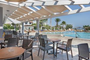 a patio with tables and chairs next to a pool at Evripides family one -bedroom 1 in Kardamaina