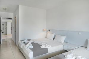 a white bed with towels on it in a room at Evripides family one -bedroom 1 in Kardamaina +25 photos