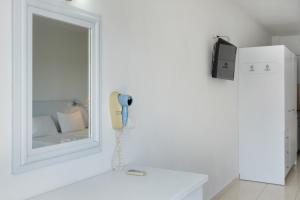 a phone hanging on a wall next to a mirror at Evripides family one -bedroom 1 in Kardamaina