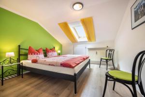 a bedroom with a bed and a green wall at Ferienwohnung Bamberger Gipfelblick in Hopferau
