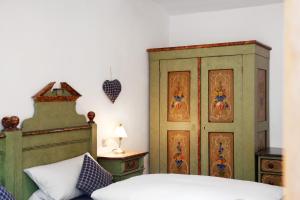 a bedroom with a bed and a wooden cabinet at Zum Schnitzer Franzl in Garmisch-Partenkirchen