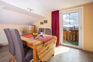a dining room with a wooden table and a window at Ferienwohnung Bamberger Gipfelblick in Hopferau