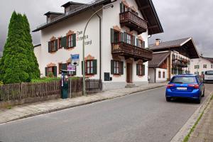 a blue car driving down a street next to a building at Zum Schnitzer Franzl in Garmisch-Partenkirchen