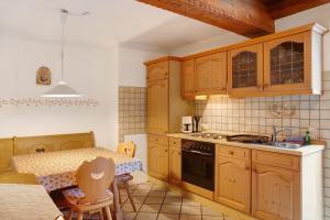 a kitchen with wooden cabinets and a table with chairs at Zum Schnitzer Franzl in Garmisch-Partenkirchen