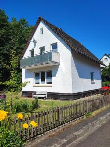 a white house with a fence and flowers at Muhrbach in Weier