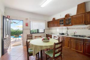 a kitchen with a table and a dining room at Casa da Alfarrobeira in Loulé